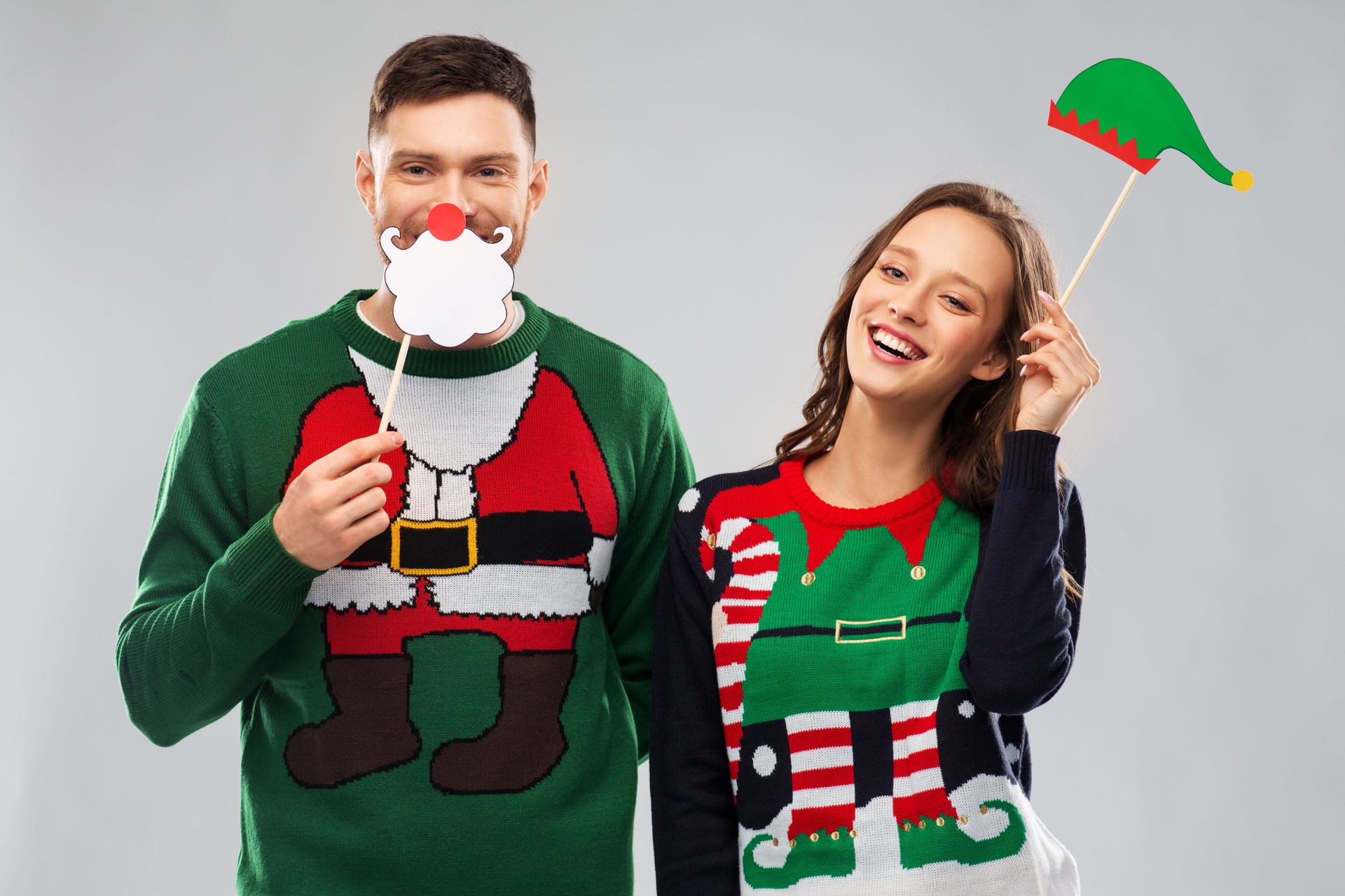 couple with christmas party props in ugly sweaters